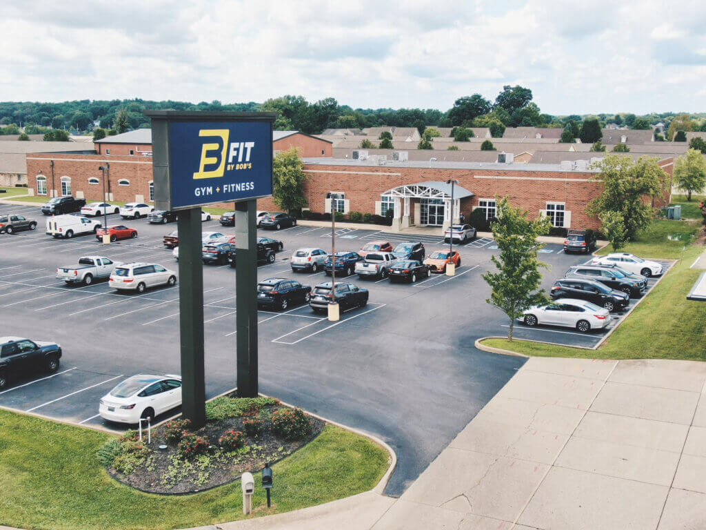 Gym with parking lot and signboard view.